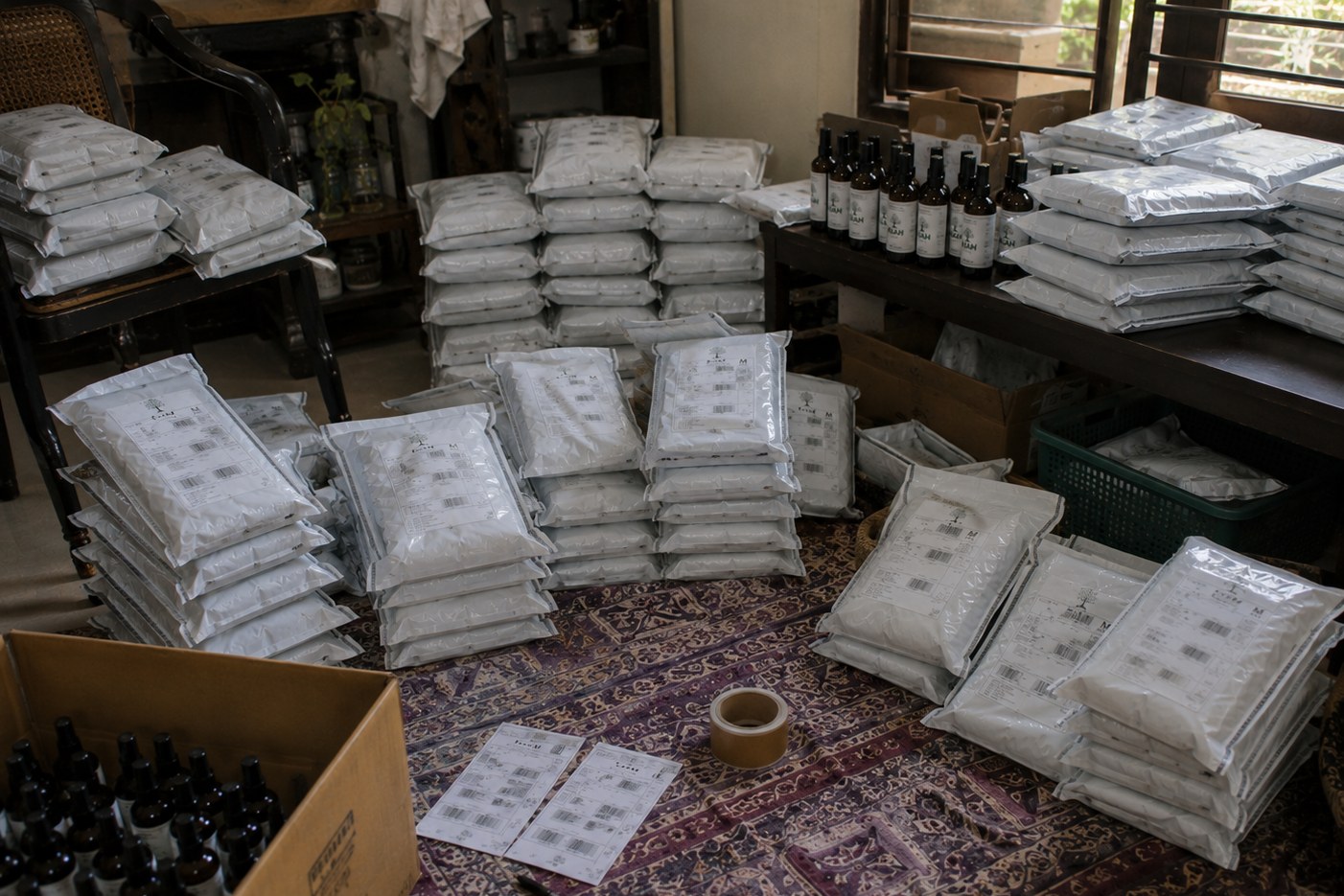 Bottles of KIAH oil beside the herbs they are made from